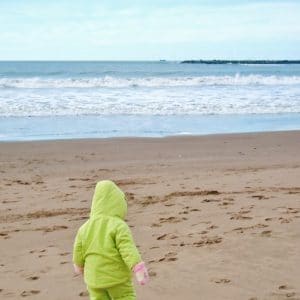 A young child walking on a beach