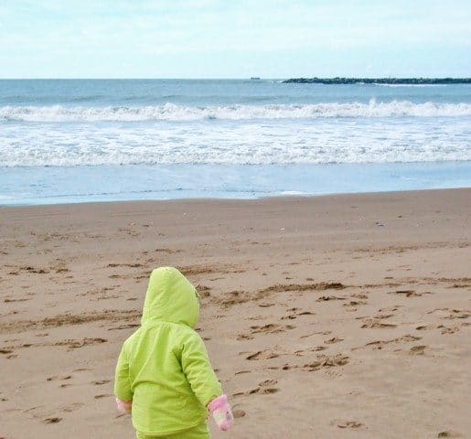 A young child walking on a beach