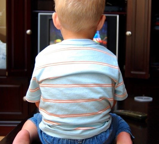 A young boy watching the TV