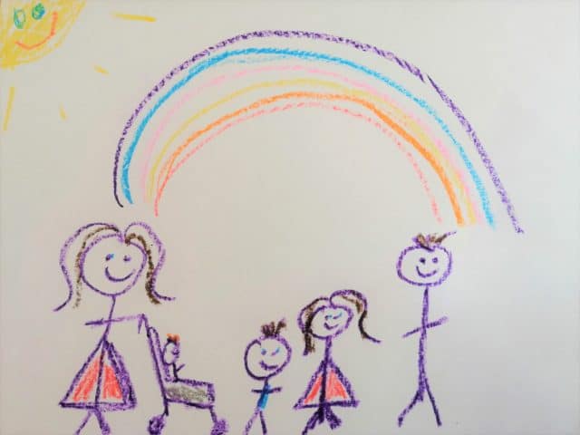 Lizzy and her children drawn in crayon by on of her children standing below a rainbow