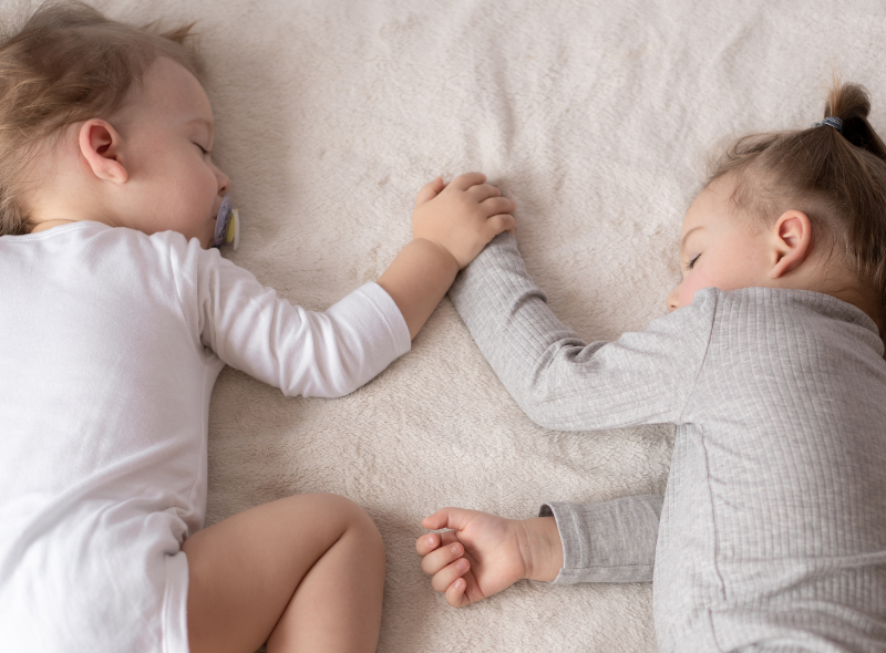 two children laying on a bed