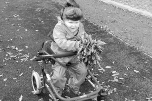 Bo collecting autumn leaves in her adapted buggy