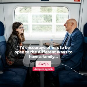 Carla sits on a train opposite her dad and encourages others to be open to the different ways to have a family