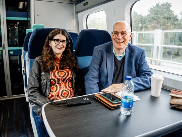 Carla and her dad Andrew, sat next to each other on a train